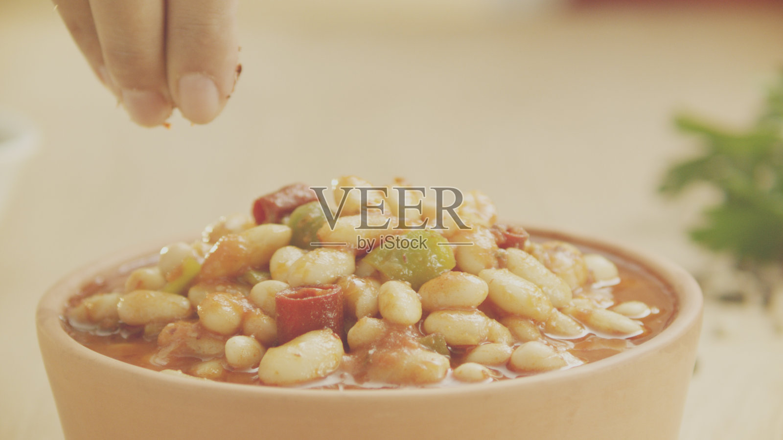 撒在土耳其风味豆子上的红辣椒粉照片摄影图片