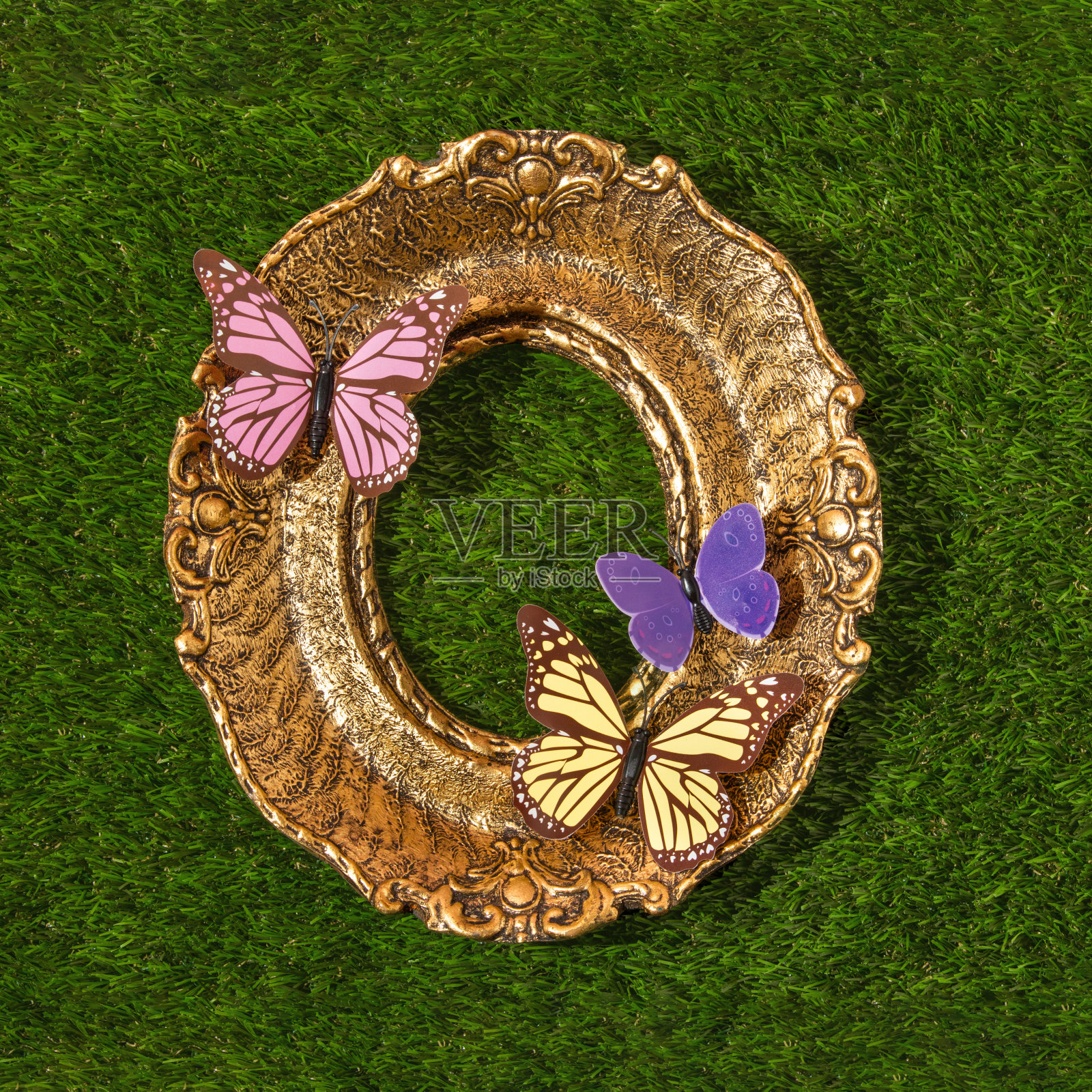 春天的创意布局与色彩丰富的蝴蝶和复古画框在绿色的草地背景。80年代、90年代复古浪漫唯美的夏日概念。简约超现实的时尚理念。照片摄影图片