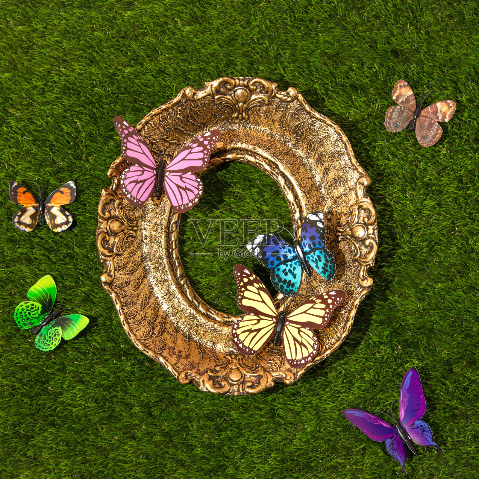 春天的创意布局与色彩丰富的蝴蝶和复古画框在绿色的草地背景。80年代、90年代复古浪漫唯美的夏日概念。简约超现实的时尚理念。照片摄影图片