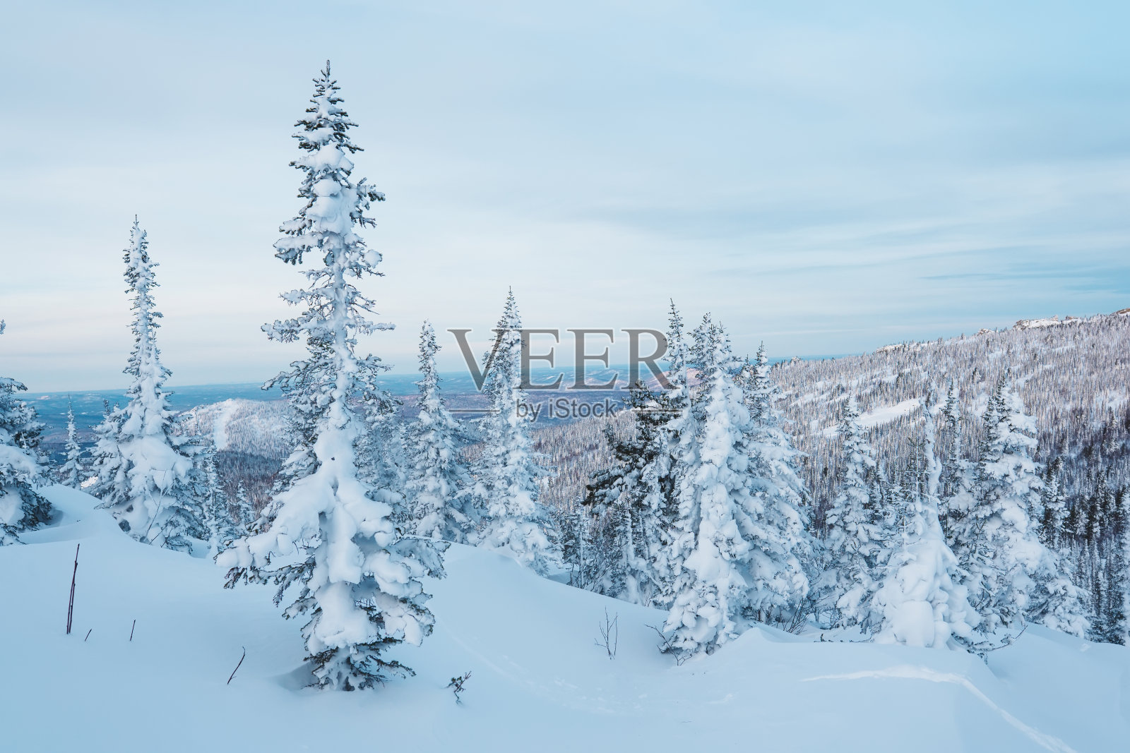 冬季景观与山林中的木屋。阴天，新下的雪。照片摄影图片