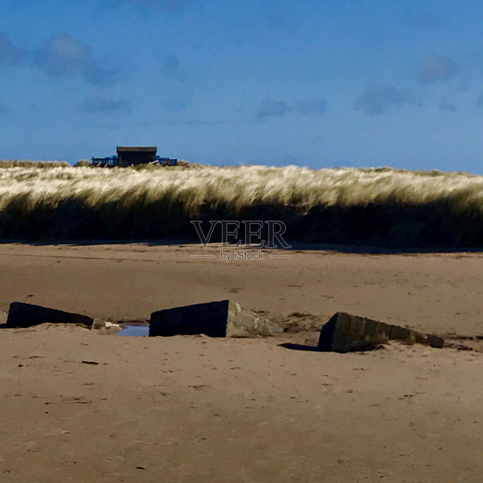 在诺森伯兰郡的比德内尔湾，埋在沙子里的二战混凝土水箱陷阱照片摄影图片