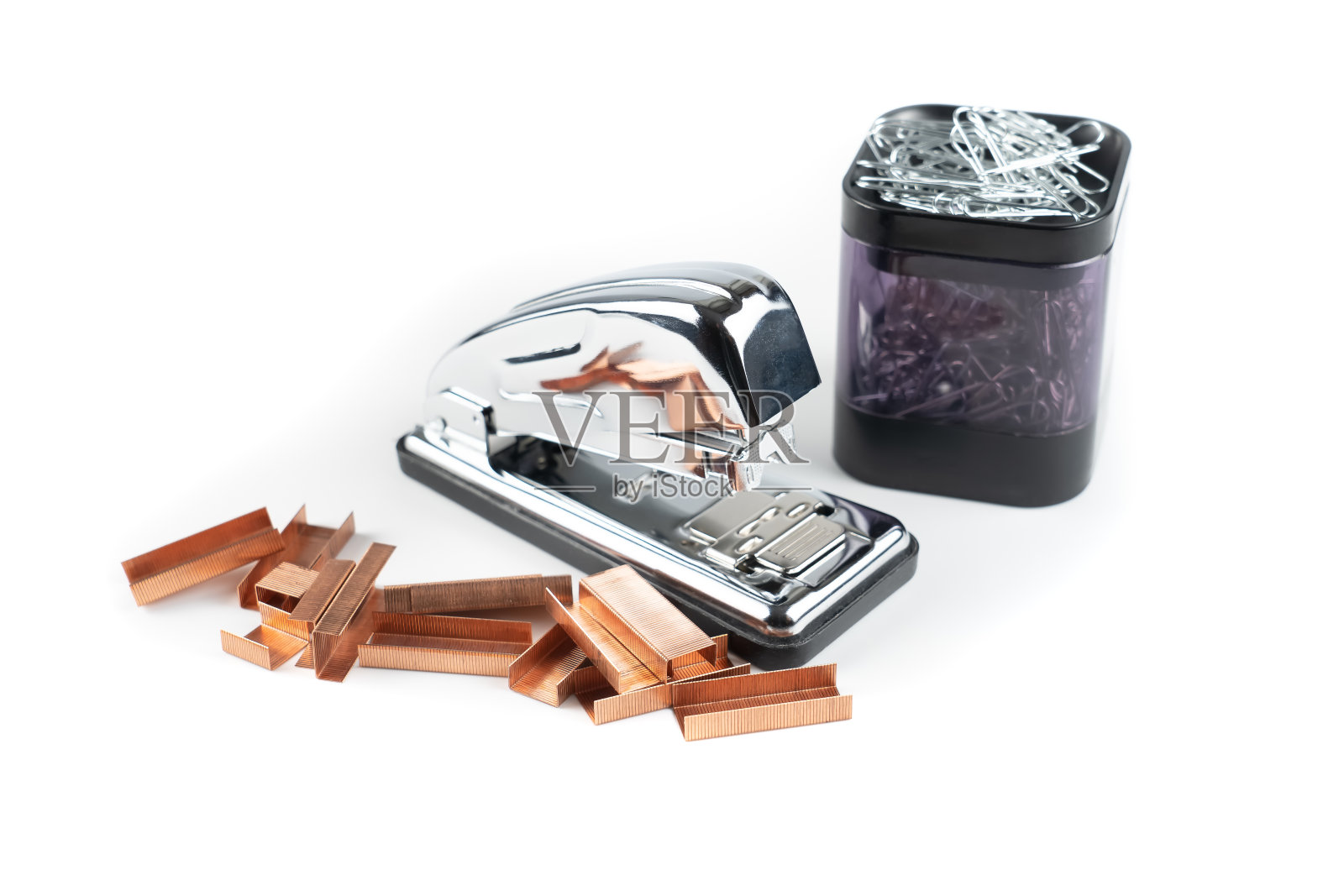 办公用品，有订书机和订书钉，还有装满夹子的集装箱。照片摄影图片