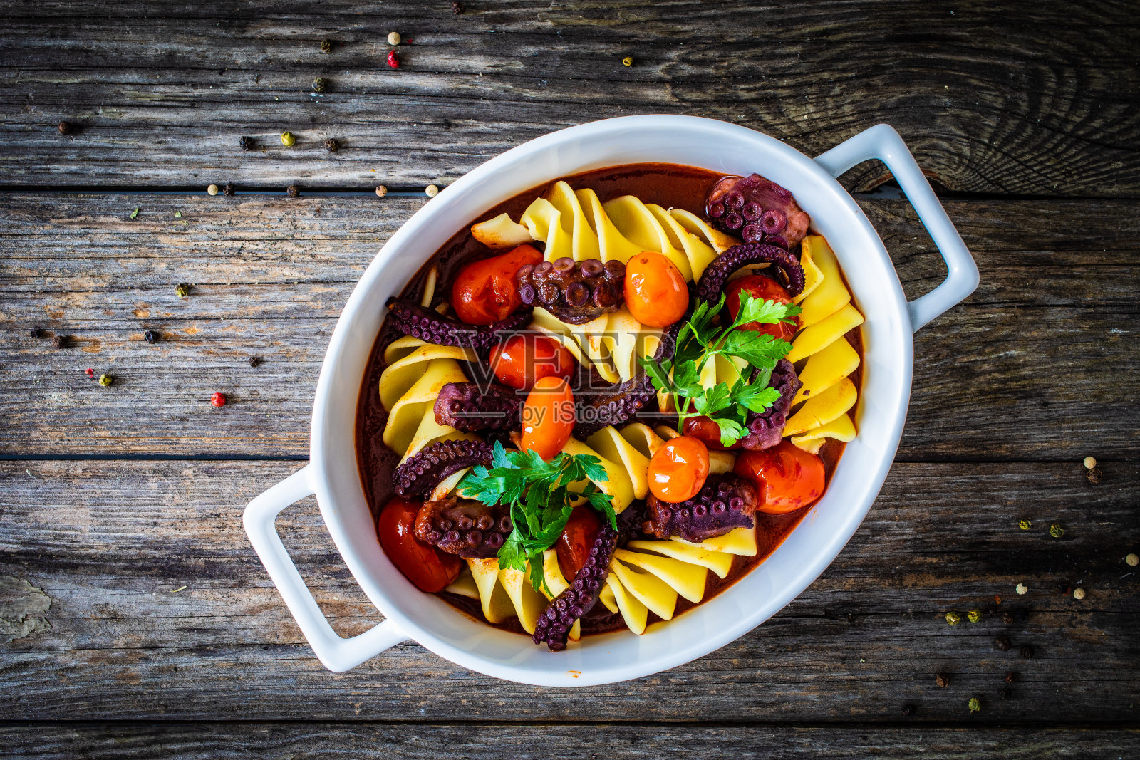 木桌上的烤章鱼和蔬菜通心粉照片摄影图片