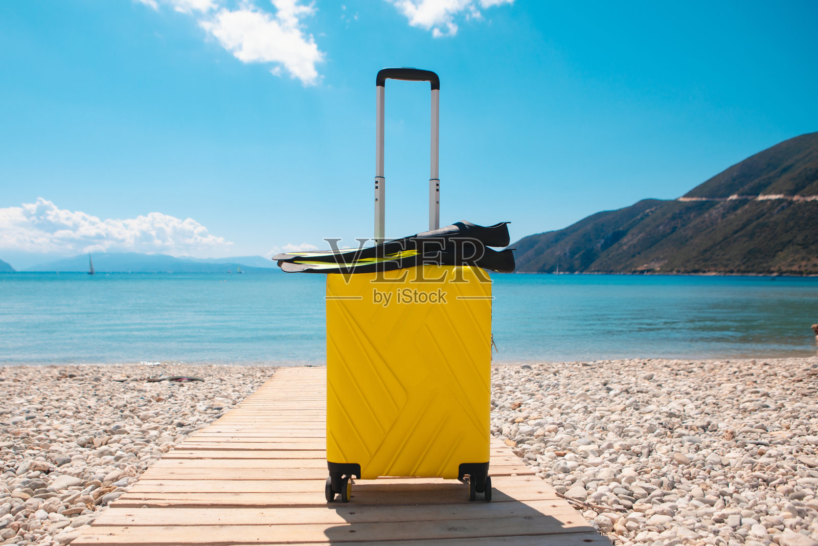 海边有个带脚蹼的手提箱照片摄影图片