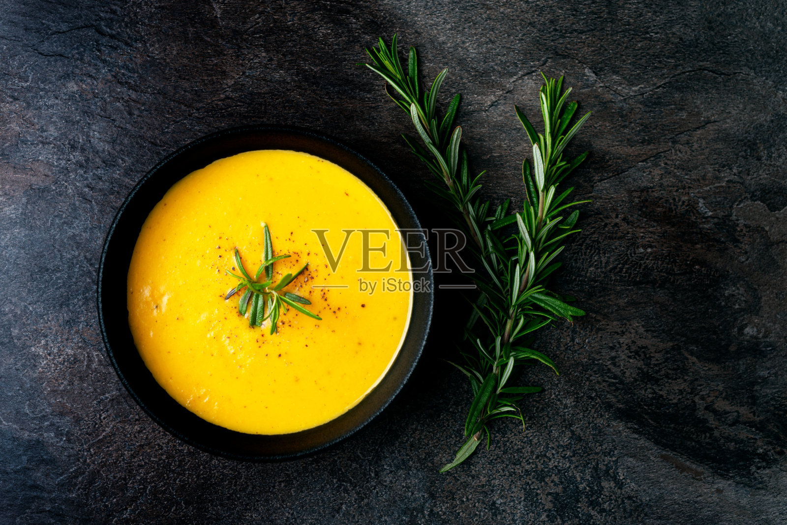 南瓜汤，亚麻餐巾，黑色的背景。照片摄影图片