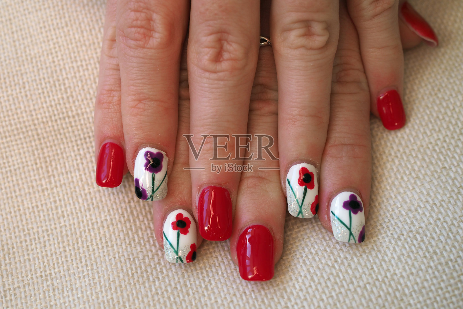 涂丙烯酸指甲与罂粟纪念主题照片摄影图片