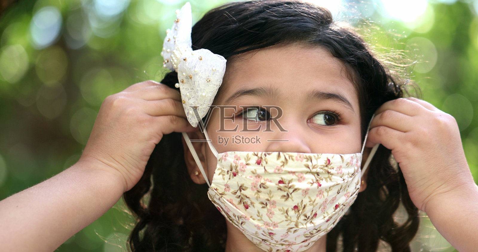 戴着新冠肺炎口罩的孩子看着相机的肖像照片摄影图片