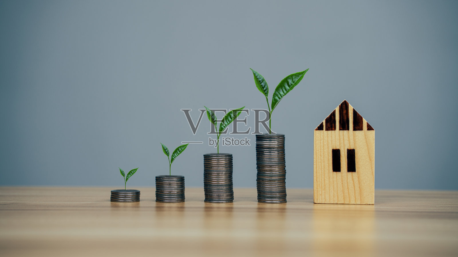 省钱模型房子和硬币在木桌背景照片摄影图片