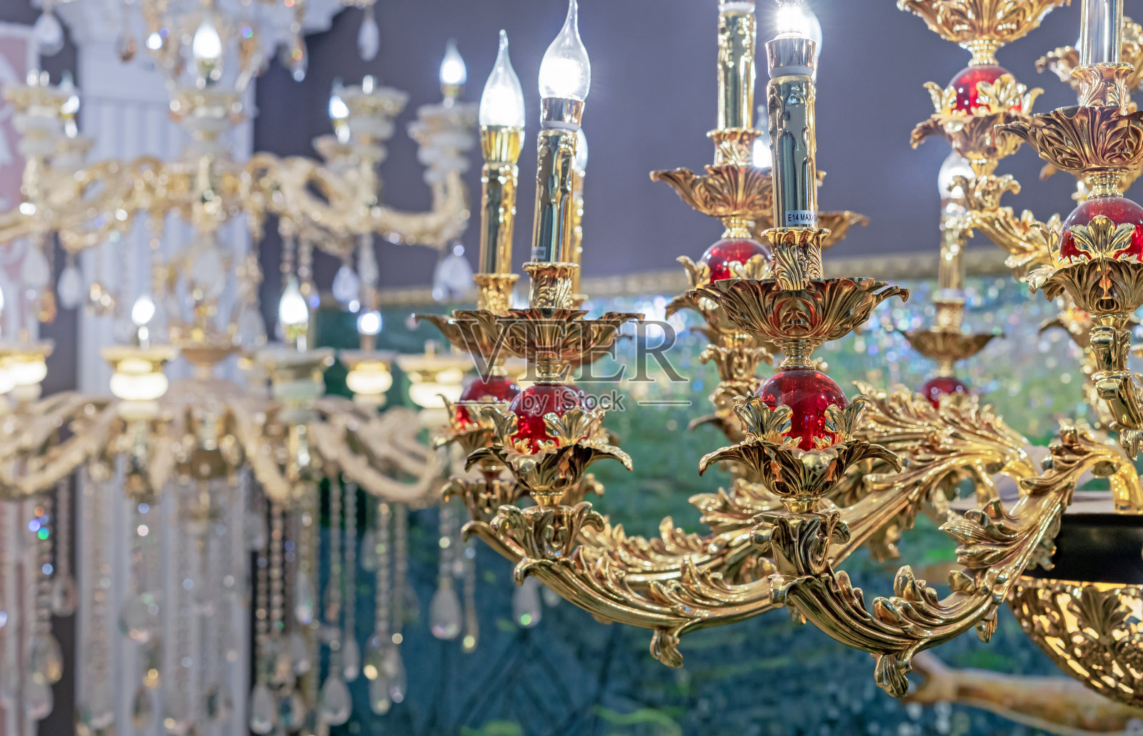 带有烛台和红色水晶球的青铜吊灯。照片摄影图片