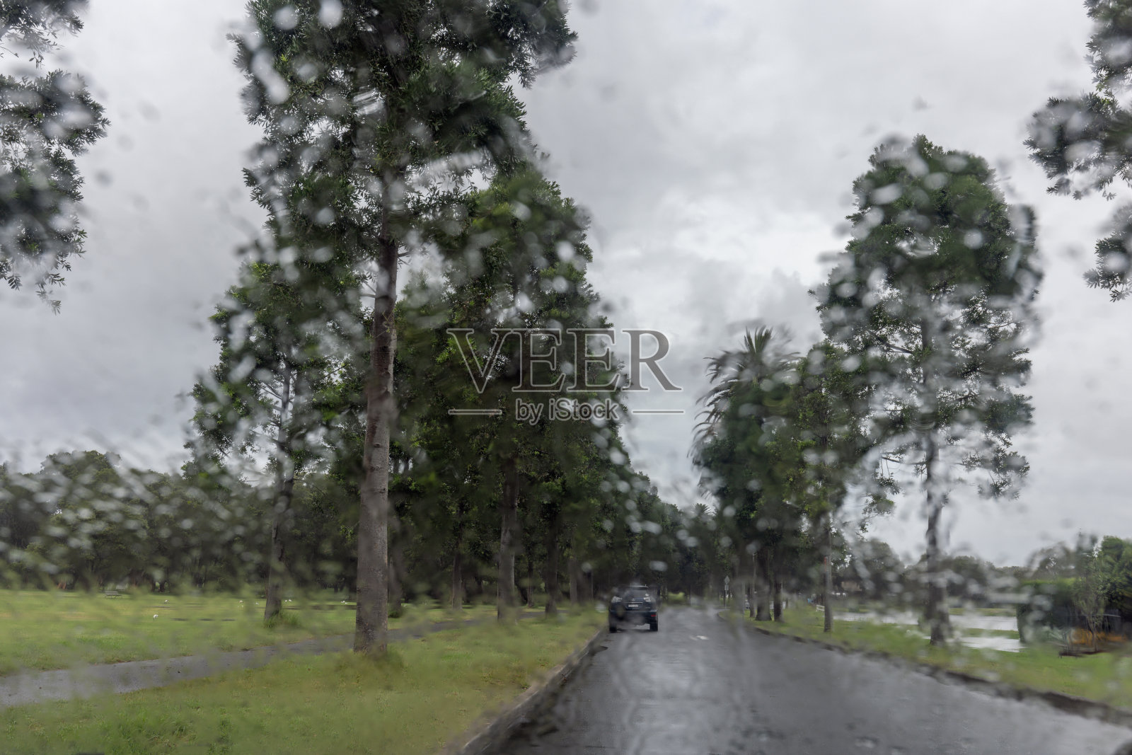 下雨时透过汽车挡风玻璃穿过前面的街道照片摄影图片