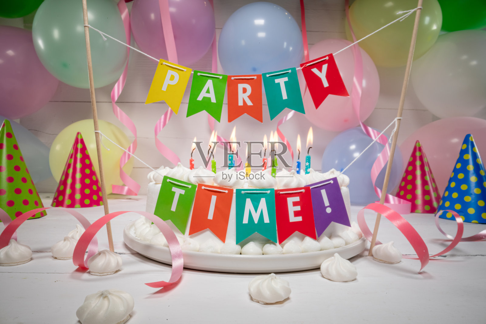 生日蛋糕上有燃烧的蜡烛，背景是气球。照片摄影图片