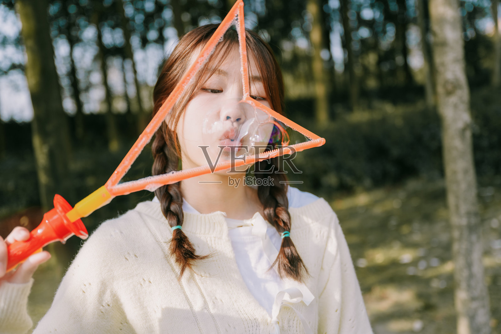 在阳光下玩泡泡的亚洲美女照片摄影图片