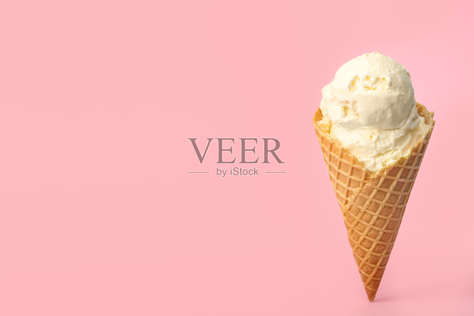 美味的华夫筒冰淇淋在粉红色的背景上。空间的文本照片摄影图片