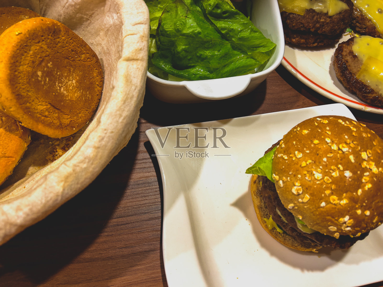 盘子里的芝士汉堡和配料。照片摄影图片