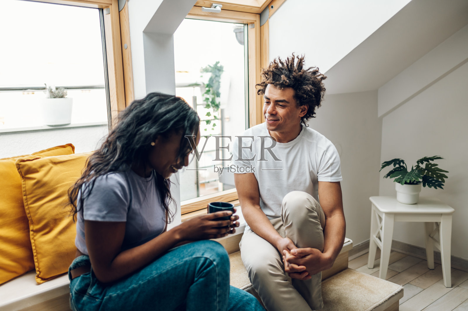 一对非裔美国夫妇坐在窗台上喝着咖啡照片摄影图片