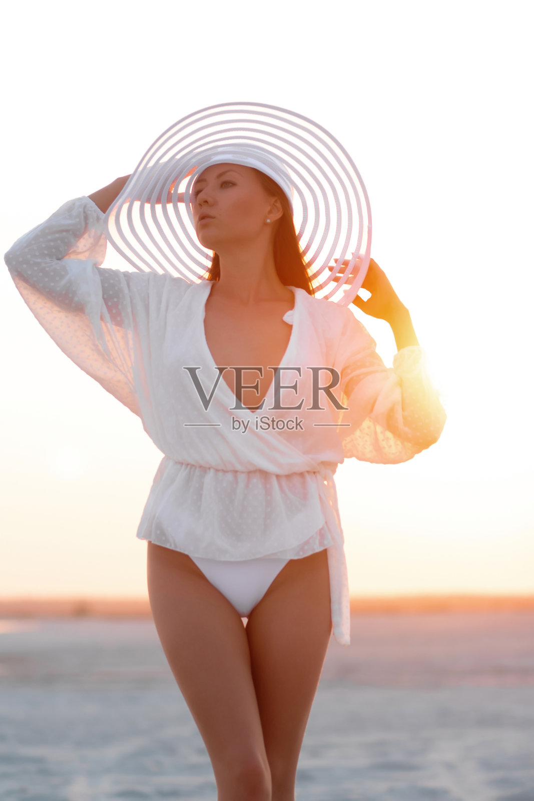 在日落的海滩穿着迷人的女人照片摄影图片