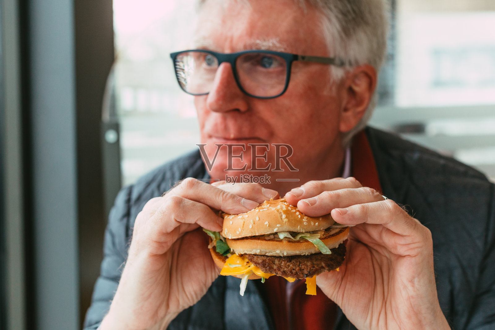 老人在快餐店吃汉堡照片摄影图片