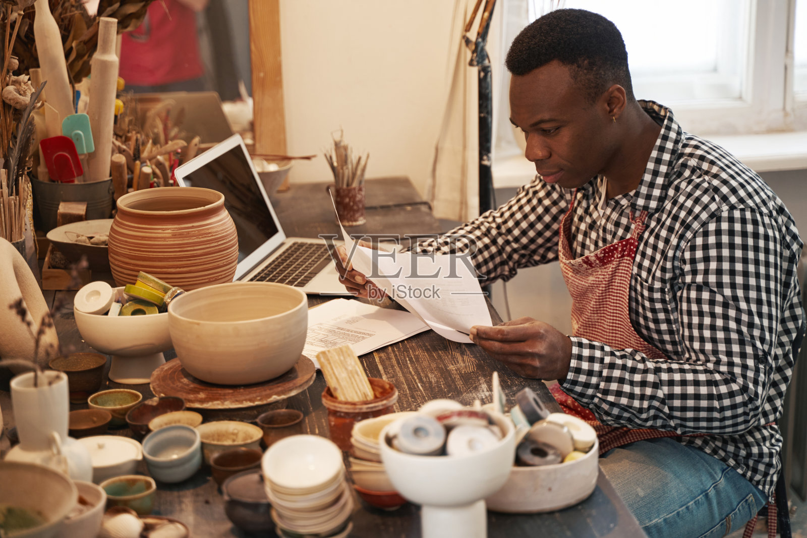 年轻男性陶艺家集中精力研究商业文件照片摄影图片
