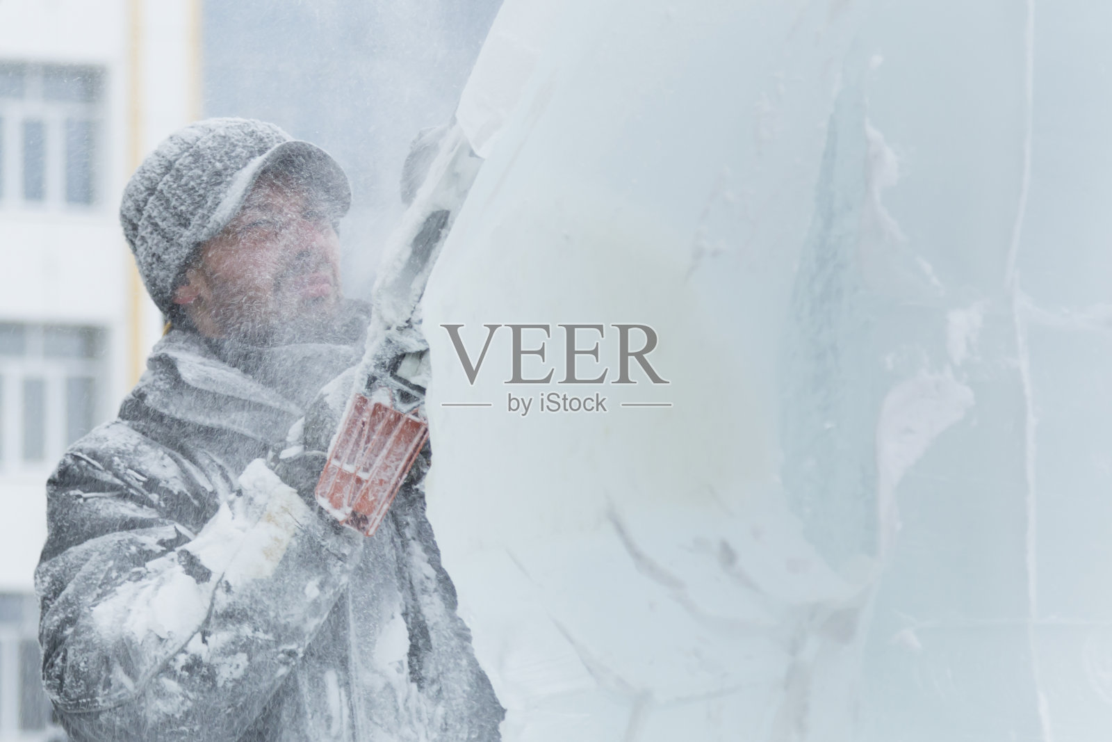 这位雕刻家用一把汽油锯从冰块上雕刻出一个雕像照片摄影图片