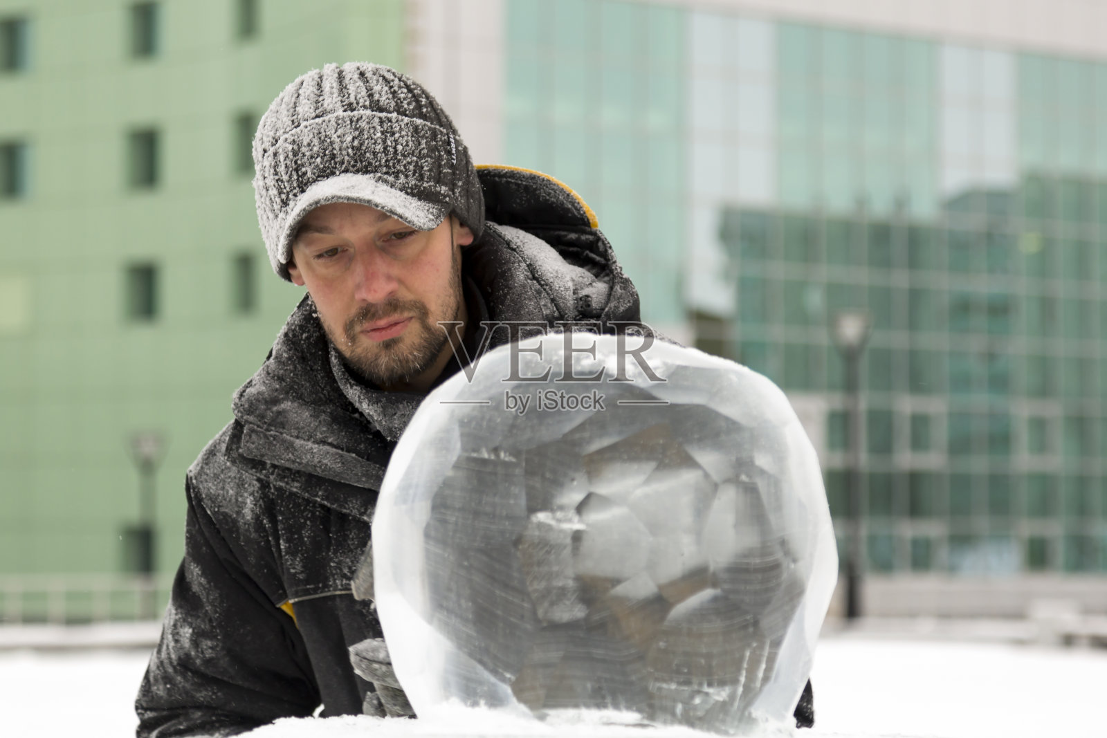 一个雕刻家的肖像，穿着冬装，手里拿着凿子在球上工作照片摄影图片