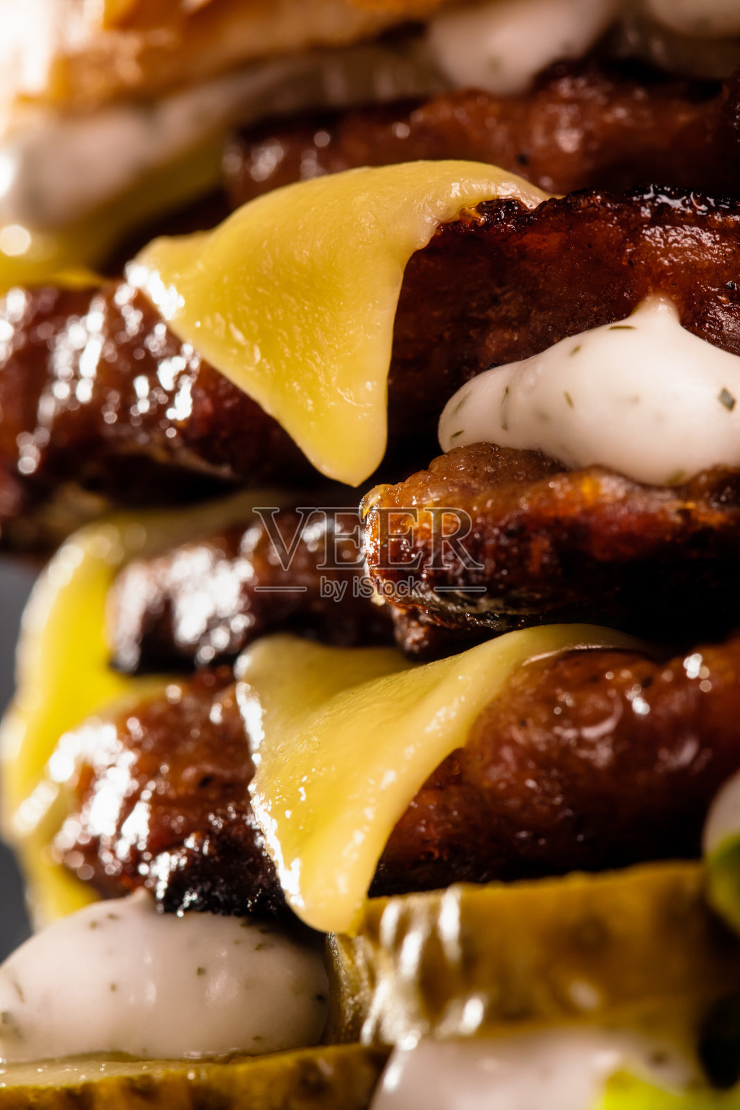 接近四份汉堡与融化的奶酪和黄瓜。照片摄影图片