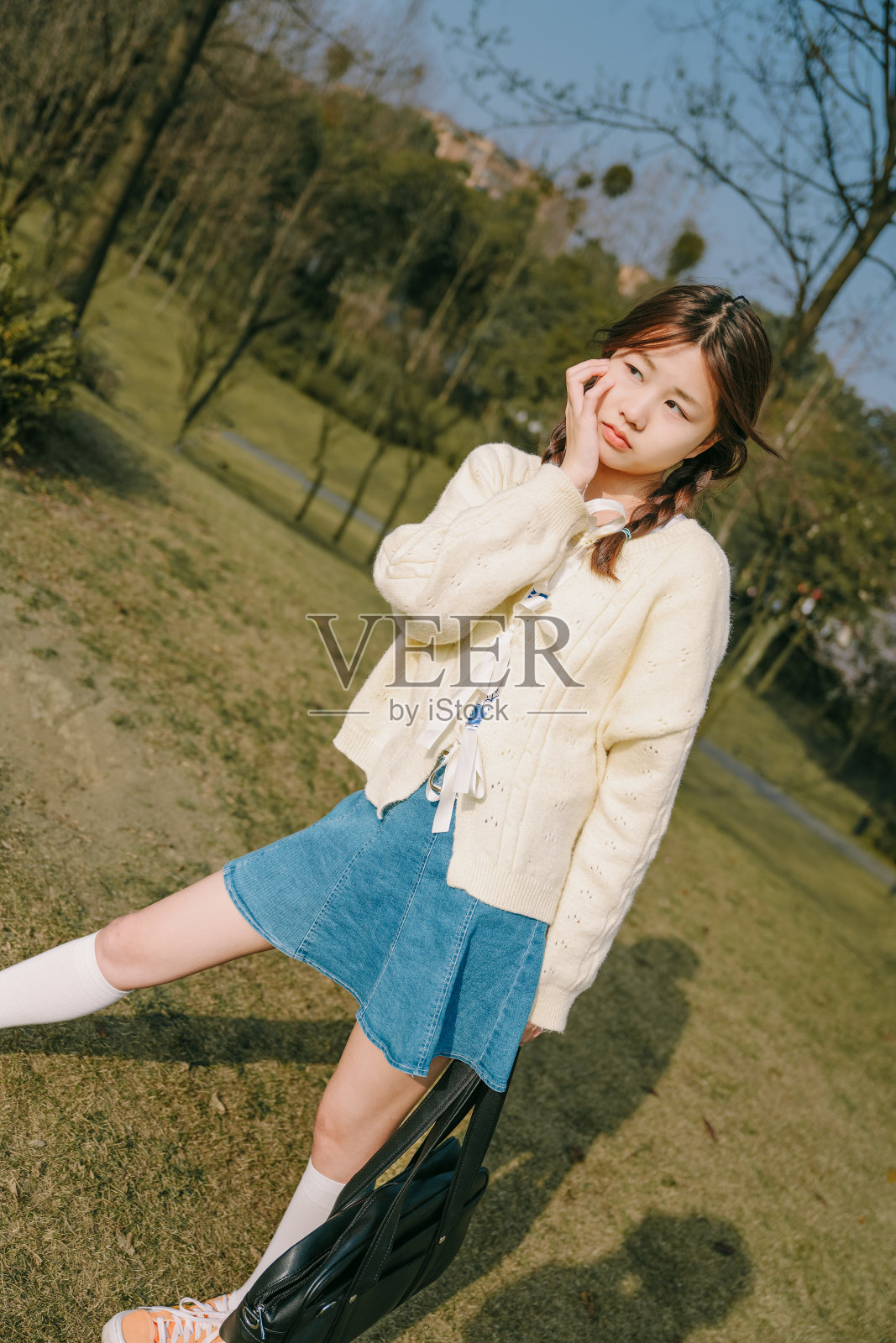 美丽的亚洲女孩在黄昏的草地上愉快地玩耍照片摄影图片