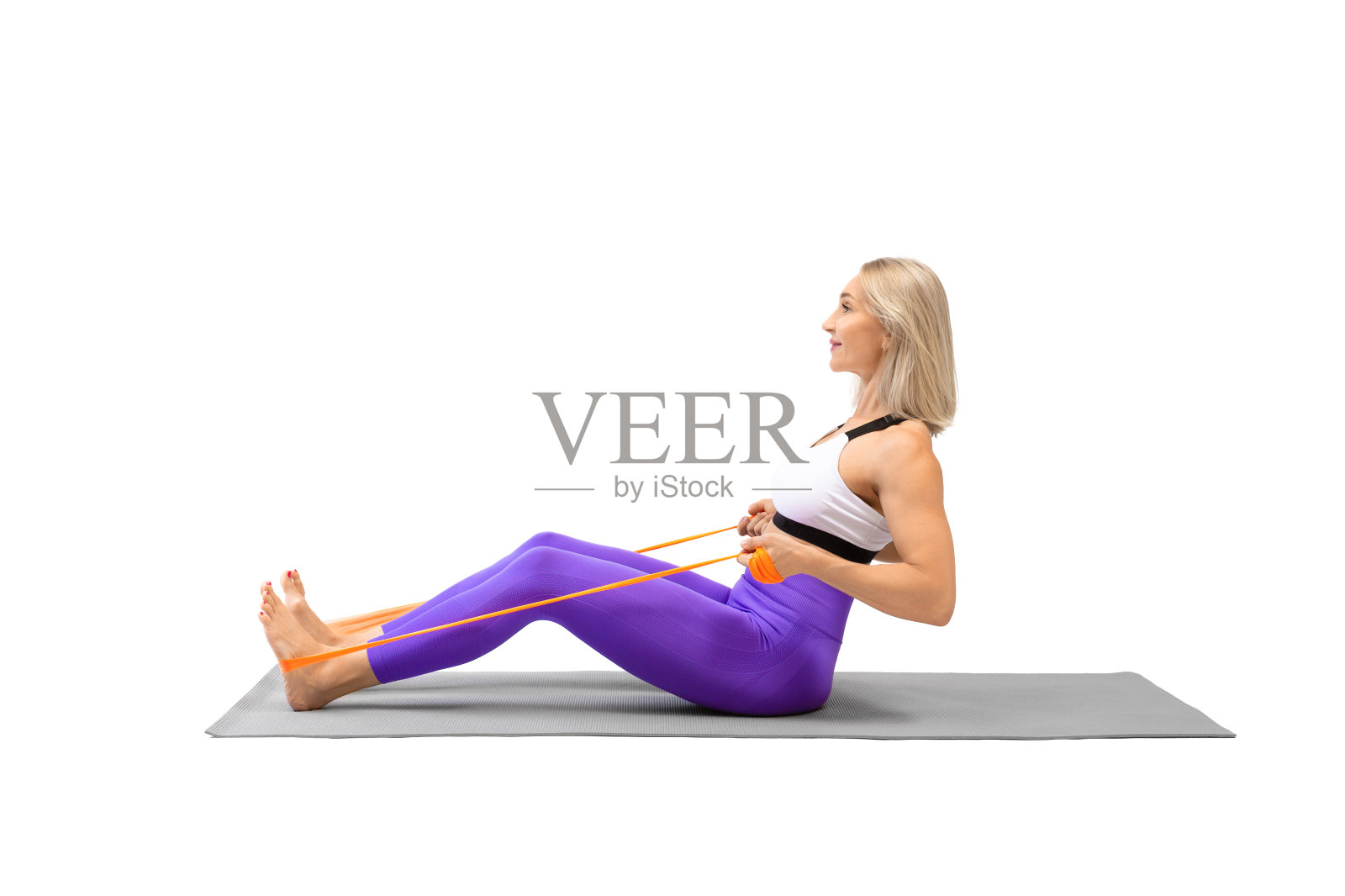 阻力带坐后排练习。迷人的女运动员坐在垫子上，使用健身道具锻炼，孤立在白色。照片摄影图片