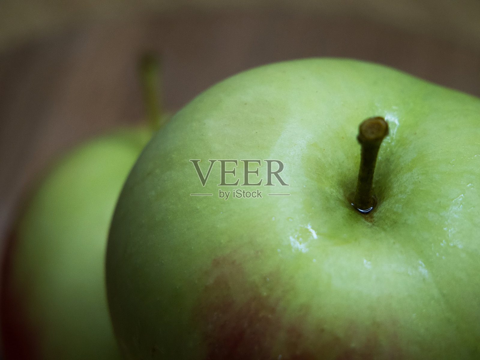 一个大绿苹果，一个特写镜头。一个潮湿的苹果。照片摄影图片