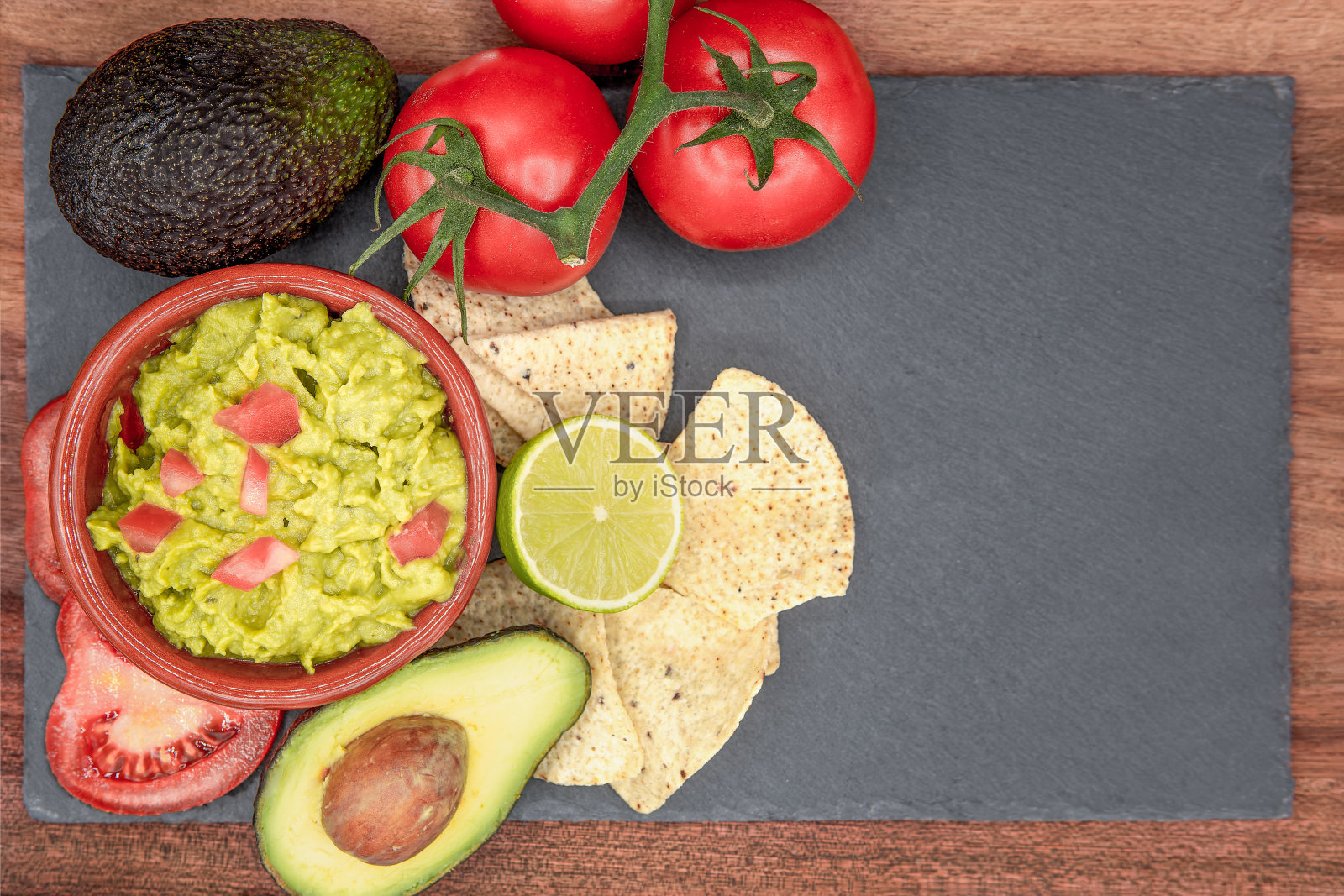 自制有机鳄梨酱、番茄和玉米片的俯视图。选择性的方法。照片摄影图片