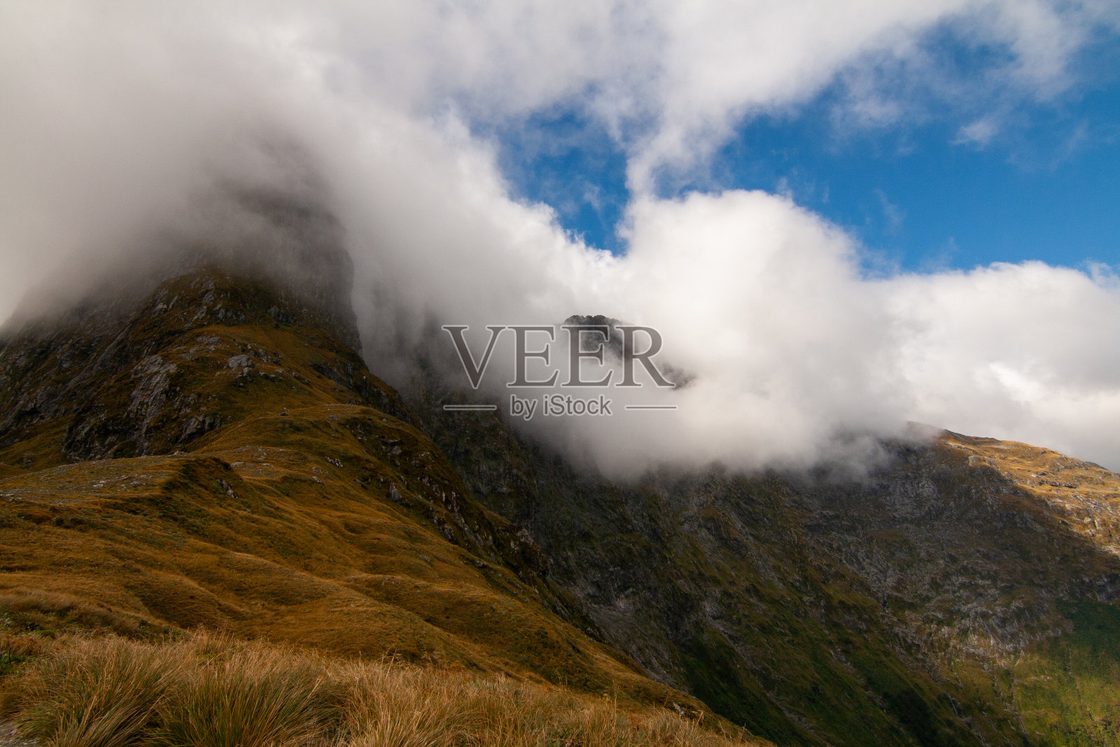 新西兰米尔福德轨道上，被柔和的雾笼罩的气球，阳光从多云的天空照射过来照片摄影图片