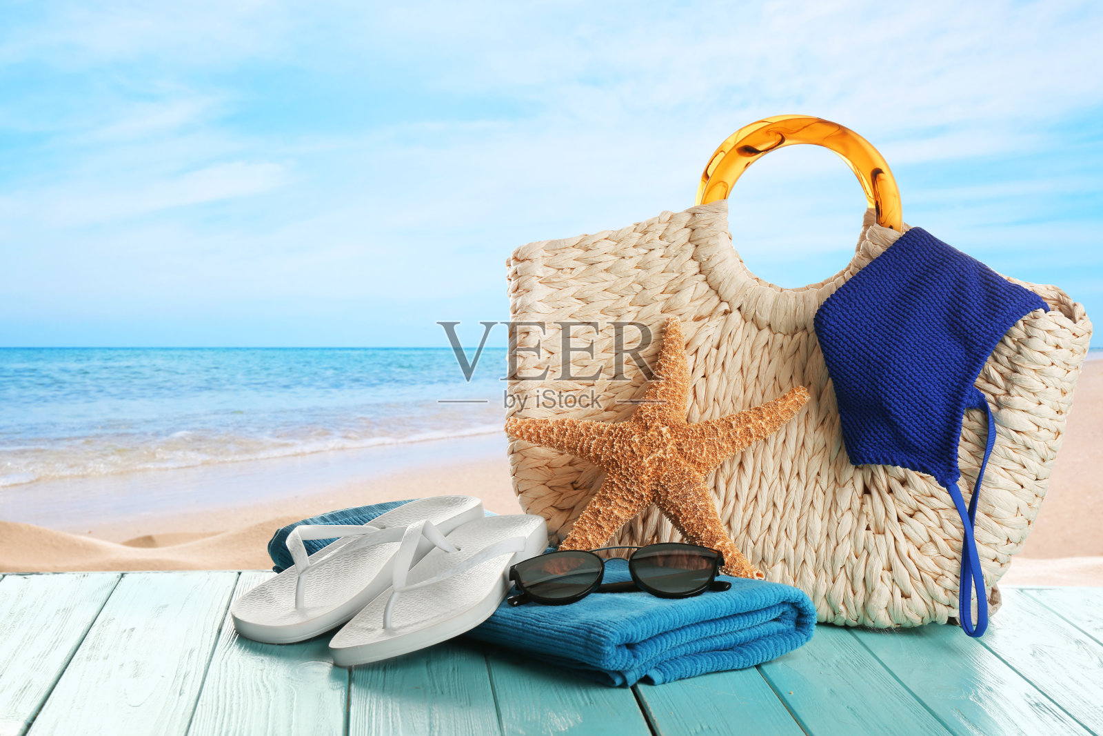 在海洋附近的绿松石木制表面的海滩配件照片摄影图片