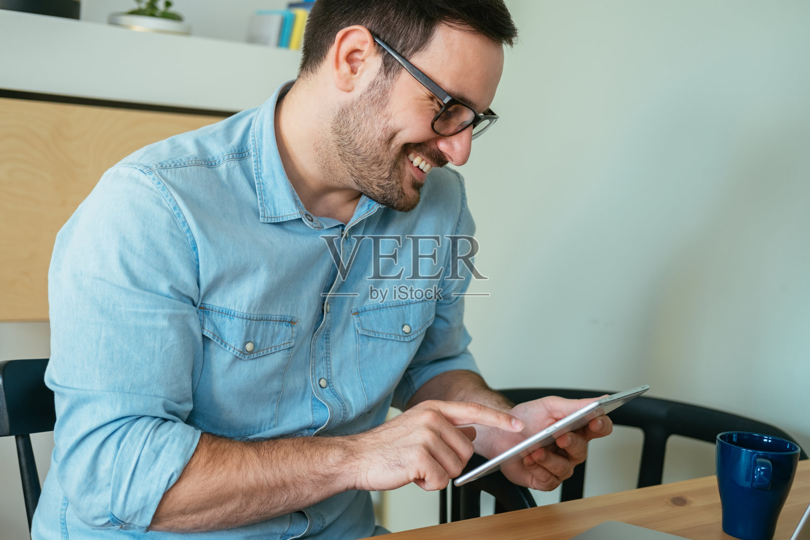 快乐商人在家里使用数码平板电脑照片摄影图片