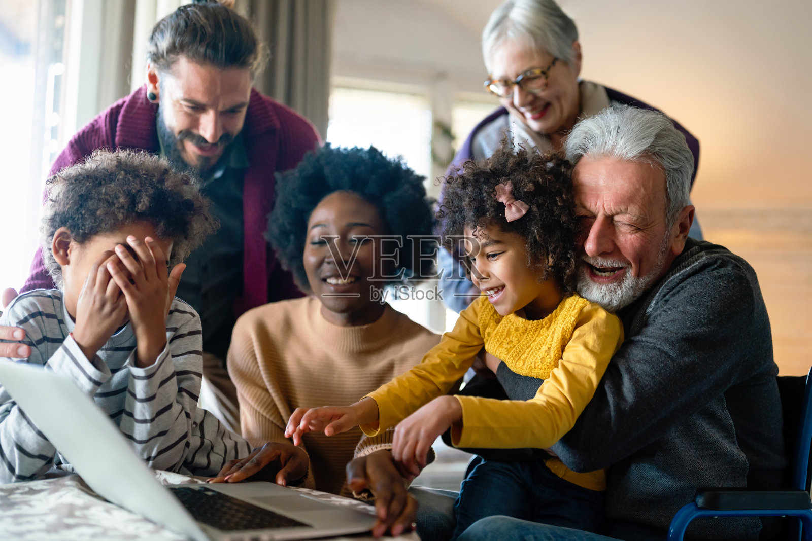 快乐的多代家庭聚集在笔记本和有乐趣的视频通话照片摄影图片