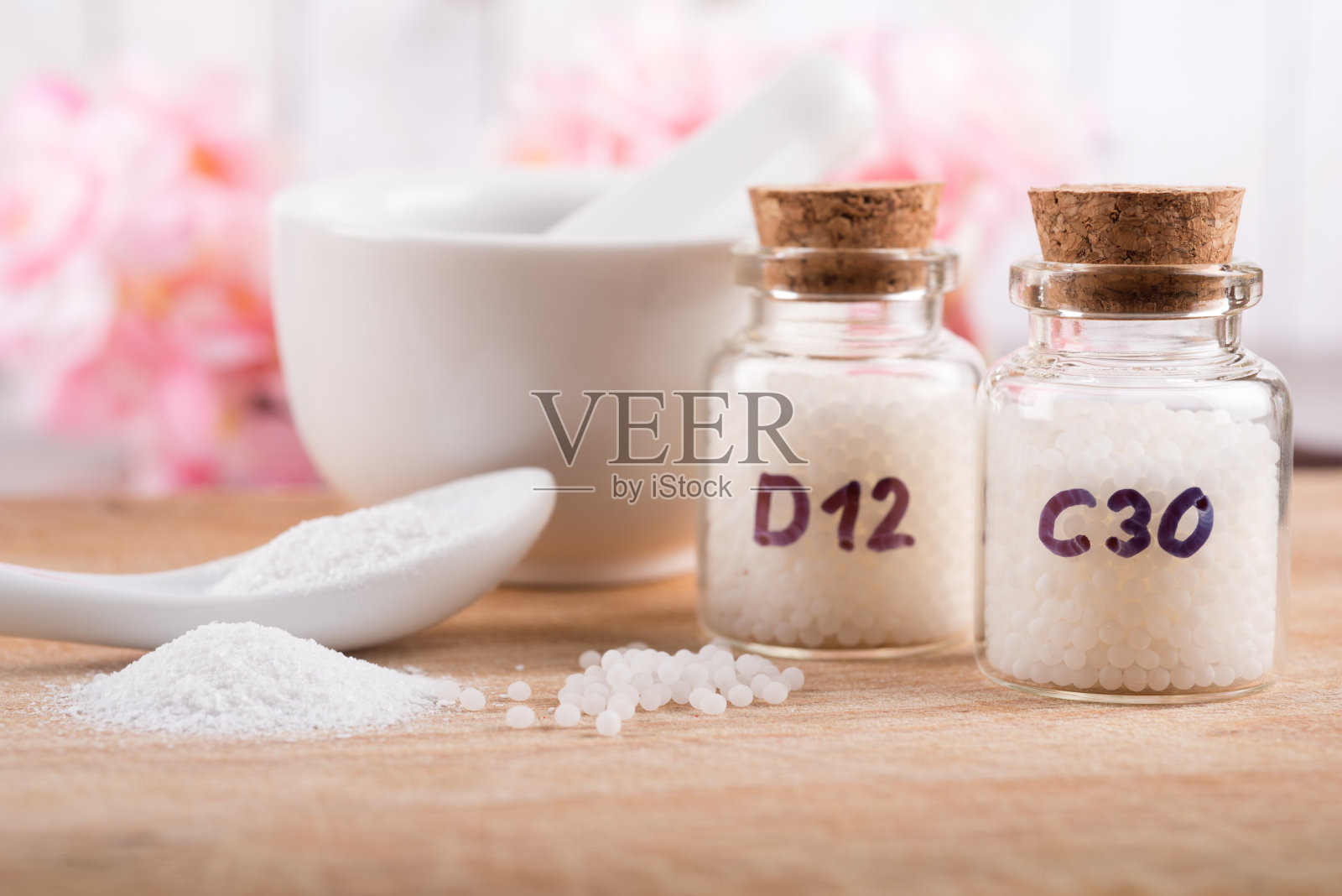 桌上的玻璃瓶里装着顺势疗法的小球，还有勺子和药粉照片摄影图片