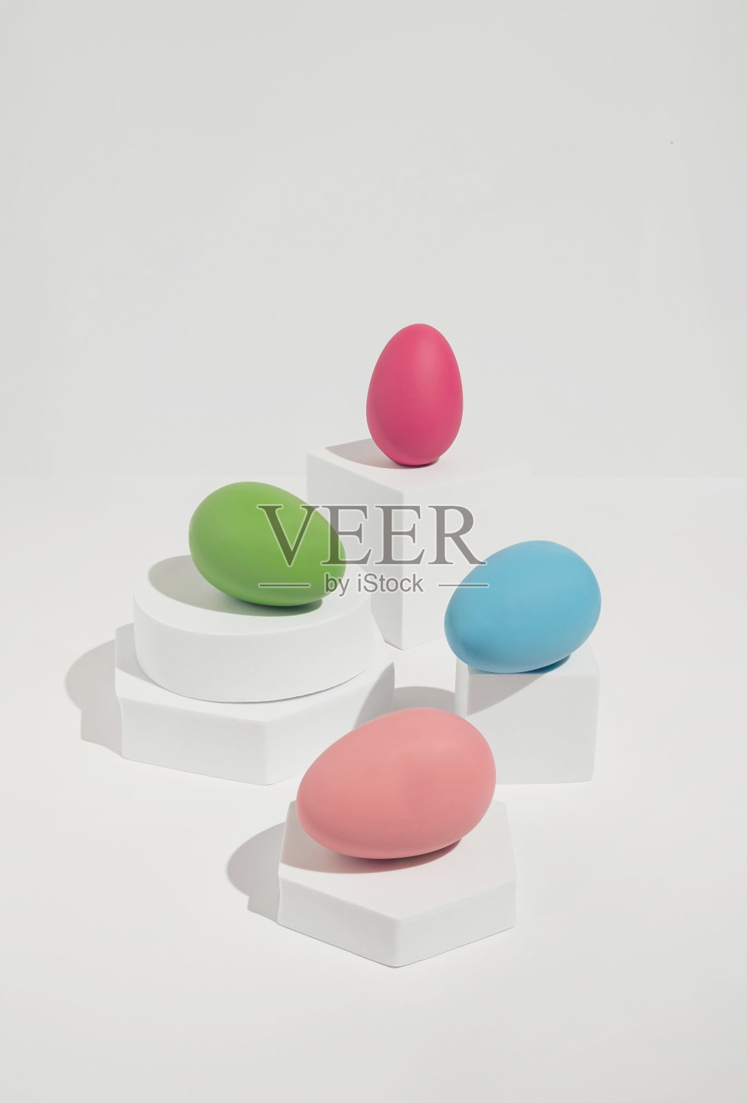 明亮的复活节概念四个彩色鸡蛋排列在白色块。现代，简约的春天美学。照片摄影图片