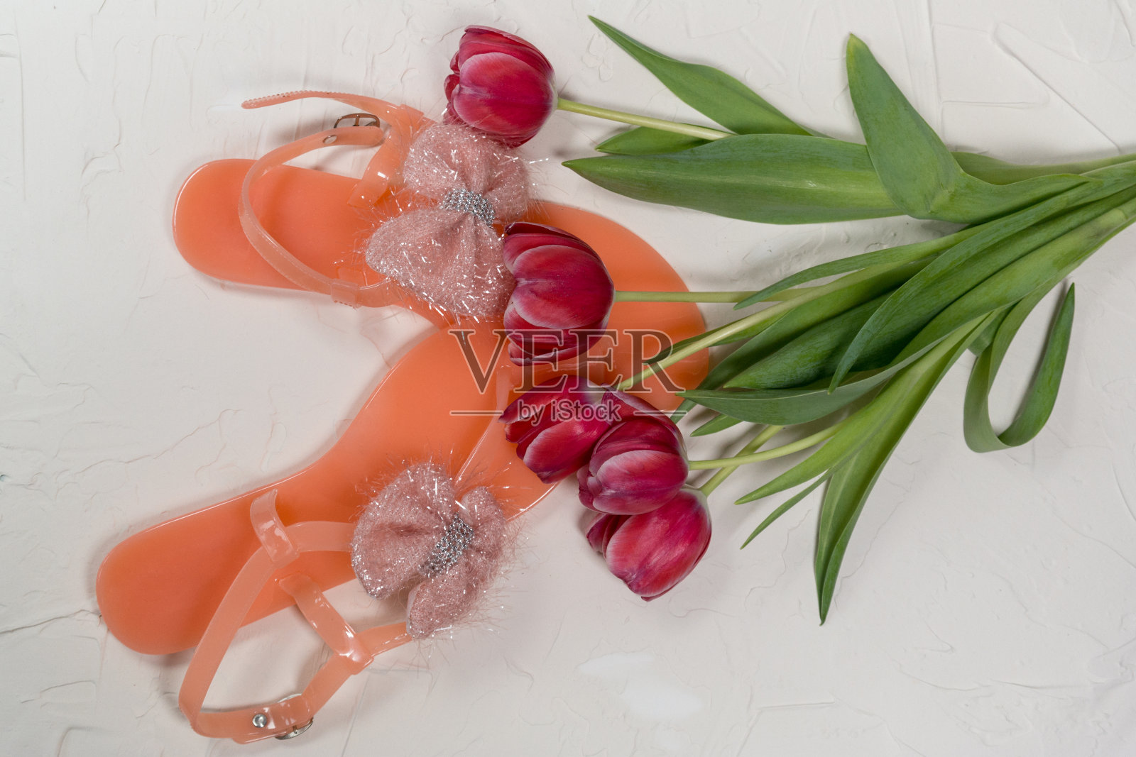 粉红色郁金香花束在灰色的背景和鞋子上照片摄影图片