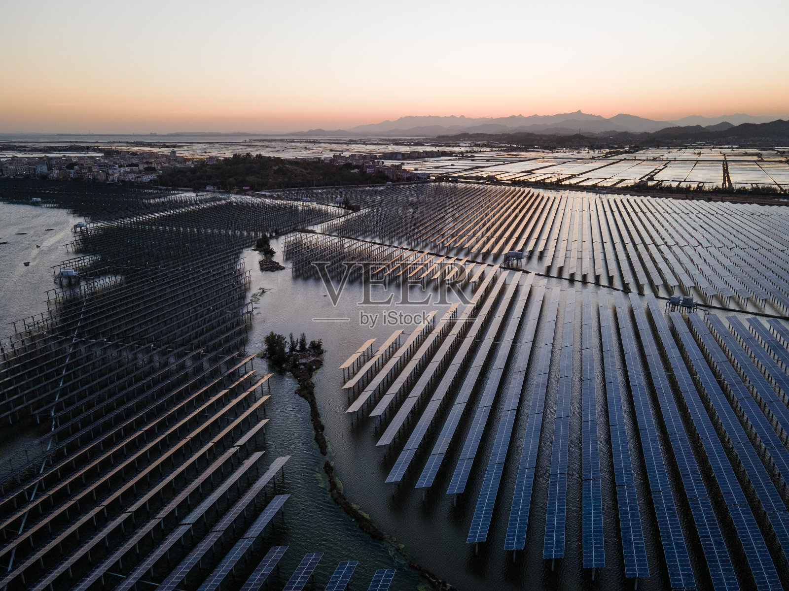 日落时海上太阳能发电厂的鸟瞰图。照片摄影图片
