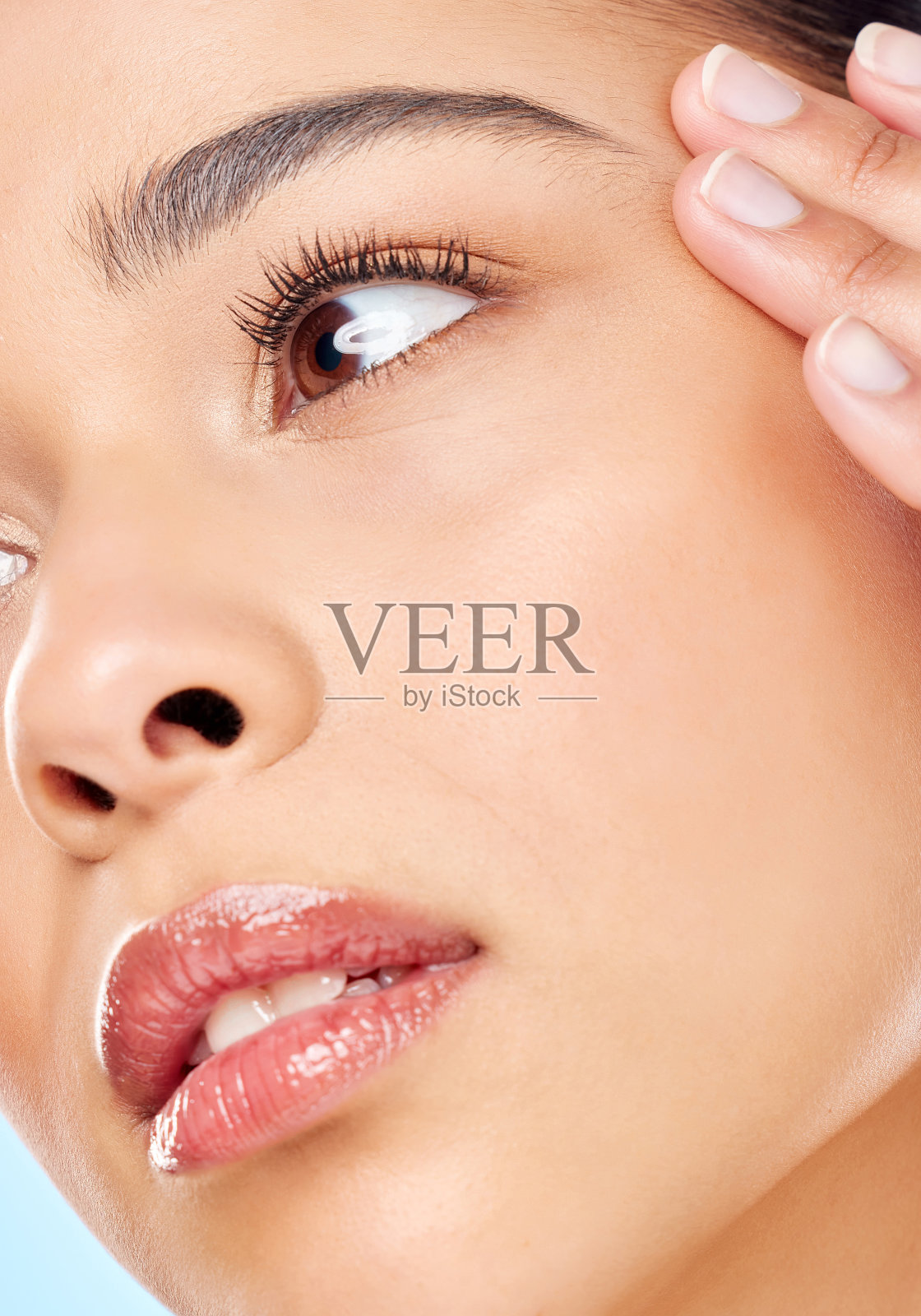 一名迷人的年轻女子在蓝色背景下摆姿势的工作室照片照片摄影图片