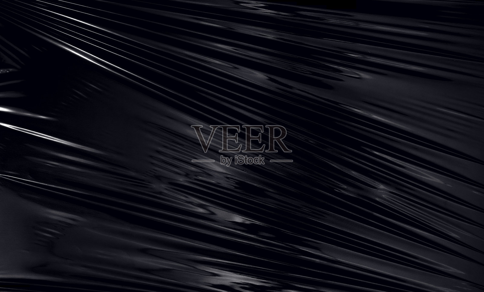 黑色背景的透明拉伸塑料薄膜。逼真的塑料包装纹理覆盖和效果照片摄影图片