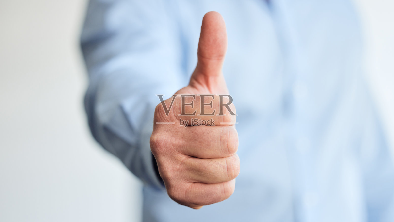 一个不认识的商人在工作时竖起大拇指的镜头照片摄影图片