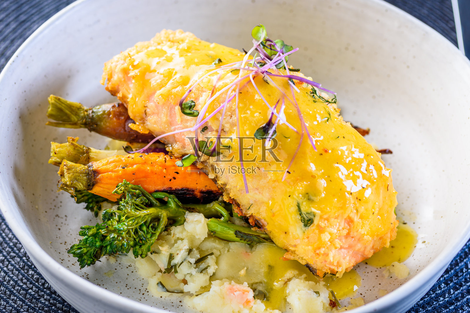 一种海鲜餐，有一片烤鲑鱼和烤蔬菜照片摄影图片