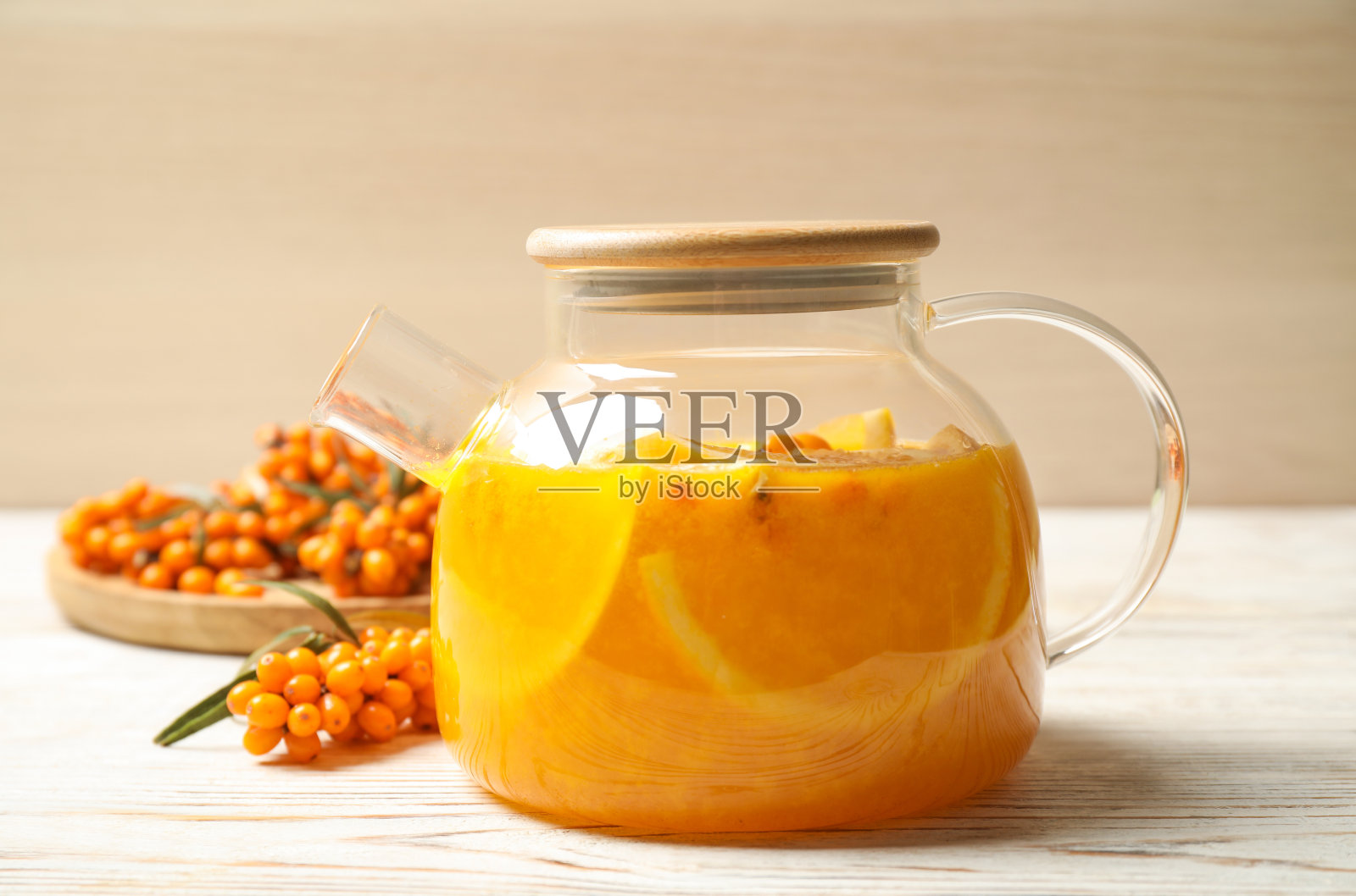 白色木桌上美味的沙棘茶配橙片和新鲜浆果照片摄影图片