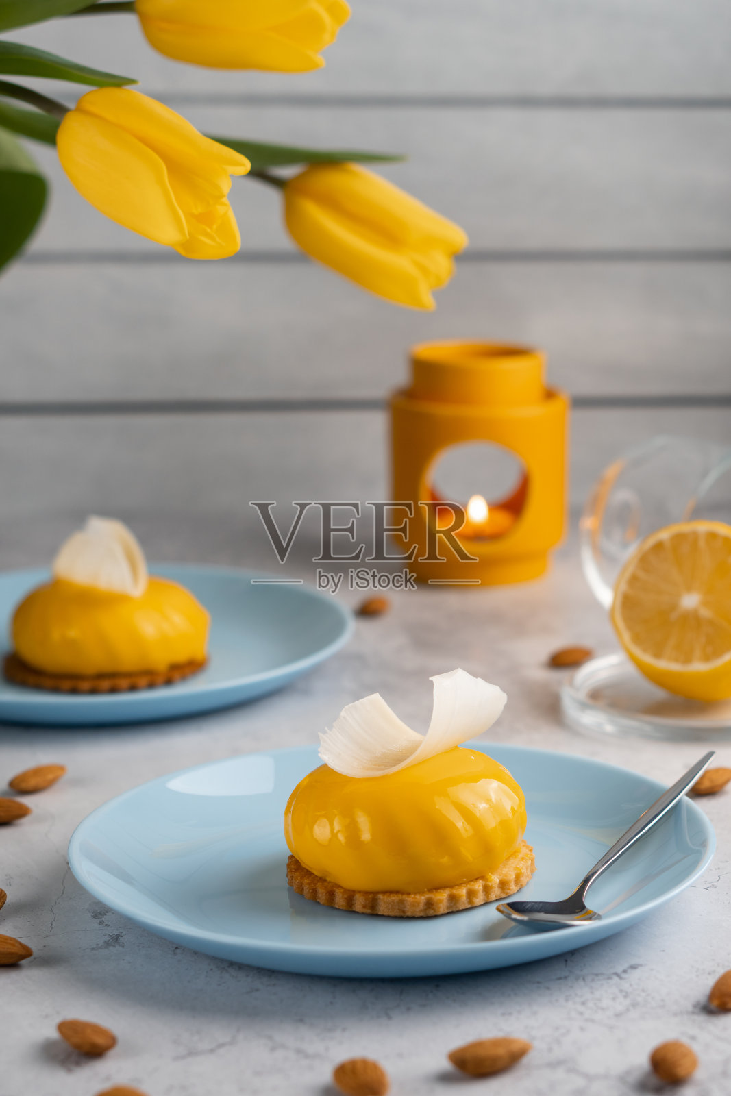 黄色的纸杯蛋糕和咖啡，混凝土背景上的黄色郁金香。早上美味的甜点照片摄影图片