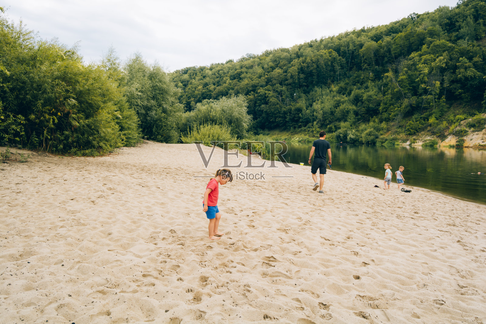 孩子们和爸爸在湖边度假照片摄影图片