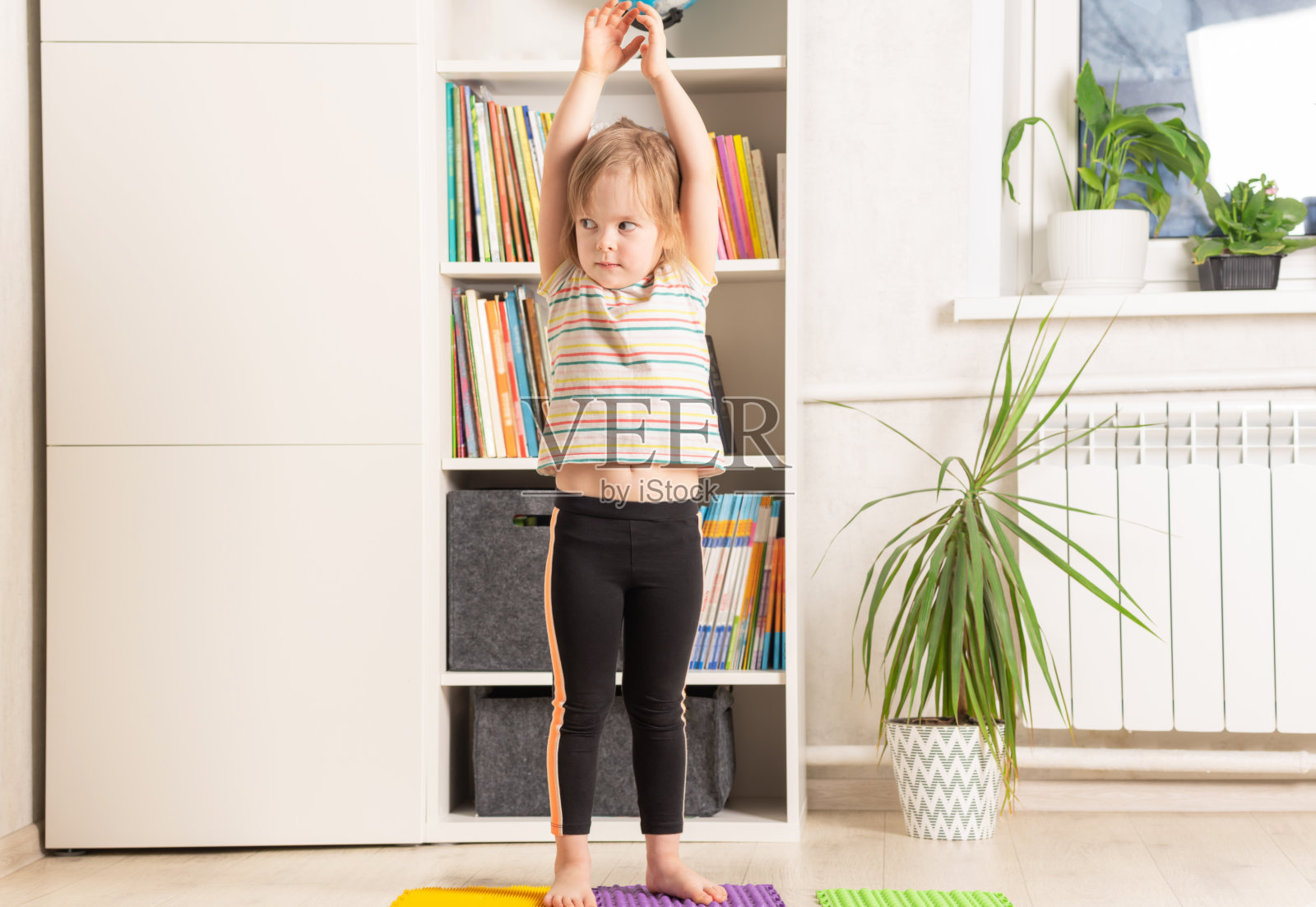 小女孩在家锻炼。身心健康趋势照片摄影图片