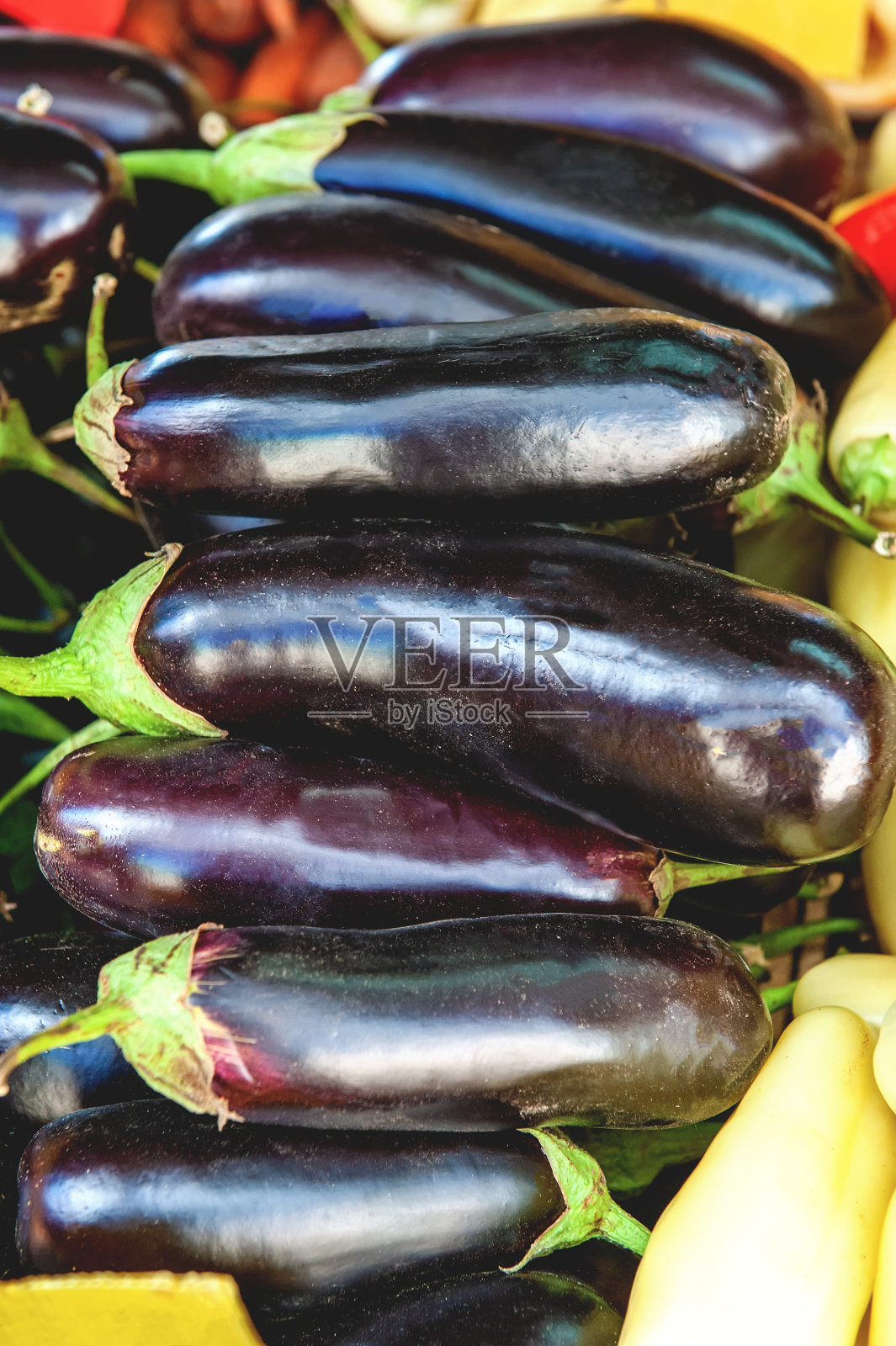农贸市场的盒子里有许多成熟的紫色茄子。素食的概念。蔬菜的背景照片摄影图片