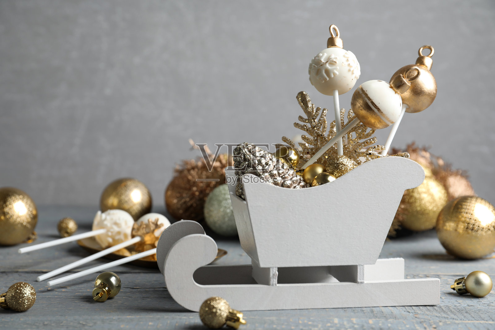 美味的圣诞主题蛋糕和节日装饰在灰色背景的木制桌子上照片摄影图片