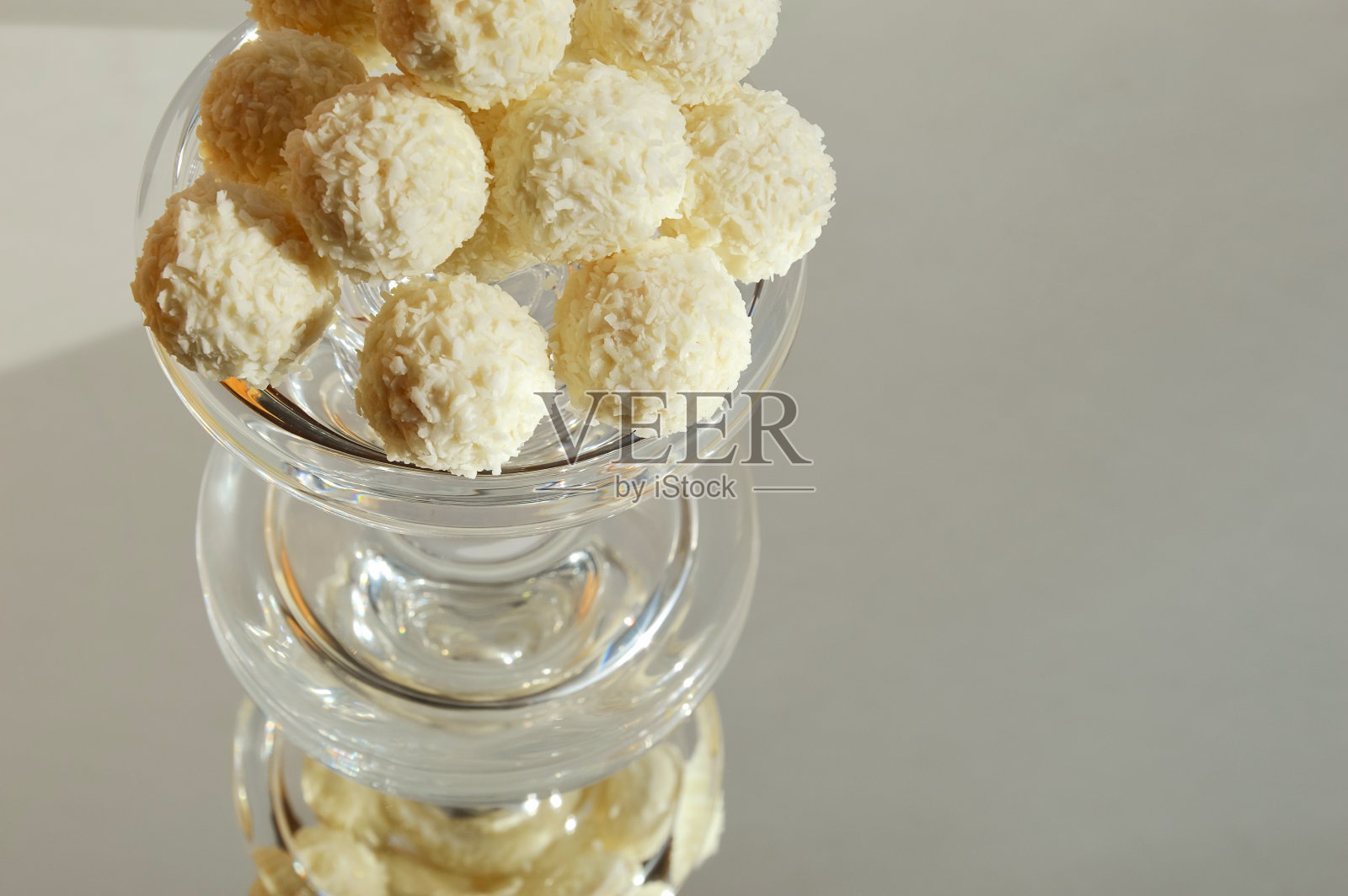 椰子球。美味的糖果配椰子片。浅背景上的甜点。照片摄影图片