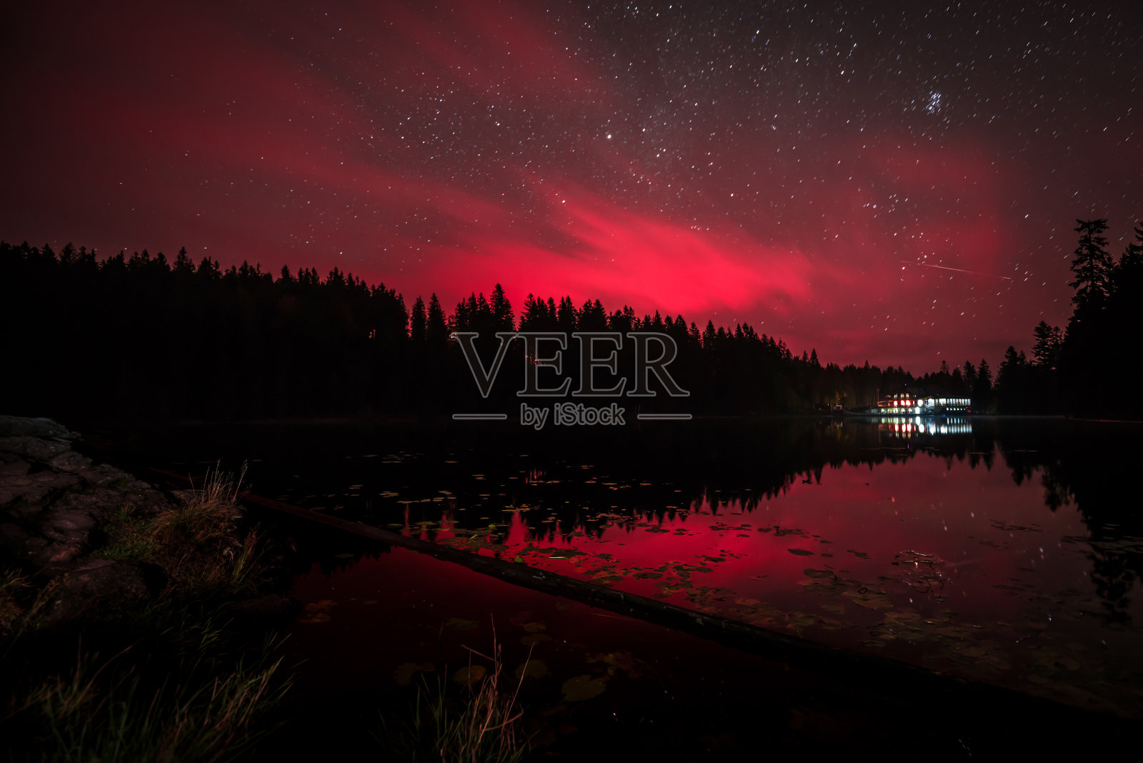 在德国巴伐利亚森林的大阿伯湖，夜晚红色的天空闪烁着银河般的星星和流星照片摄影图片