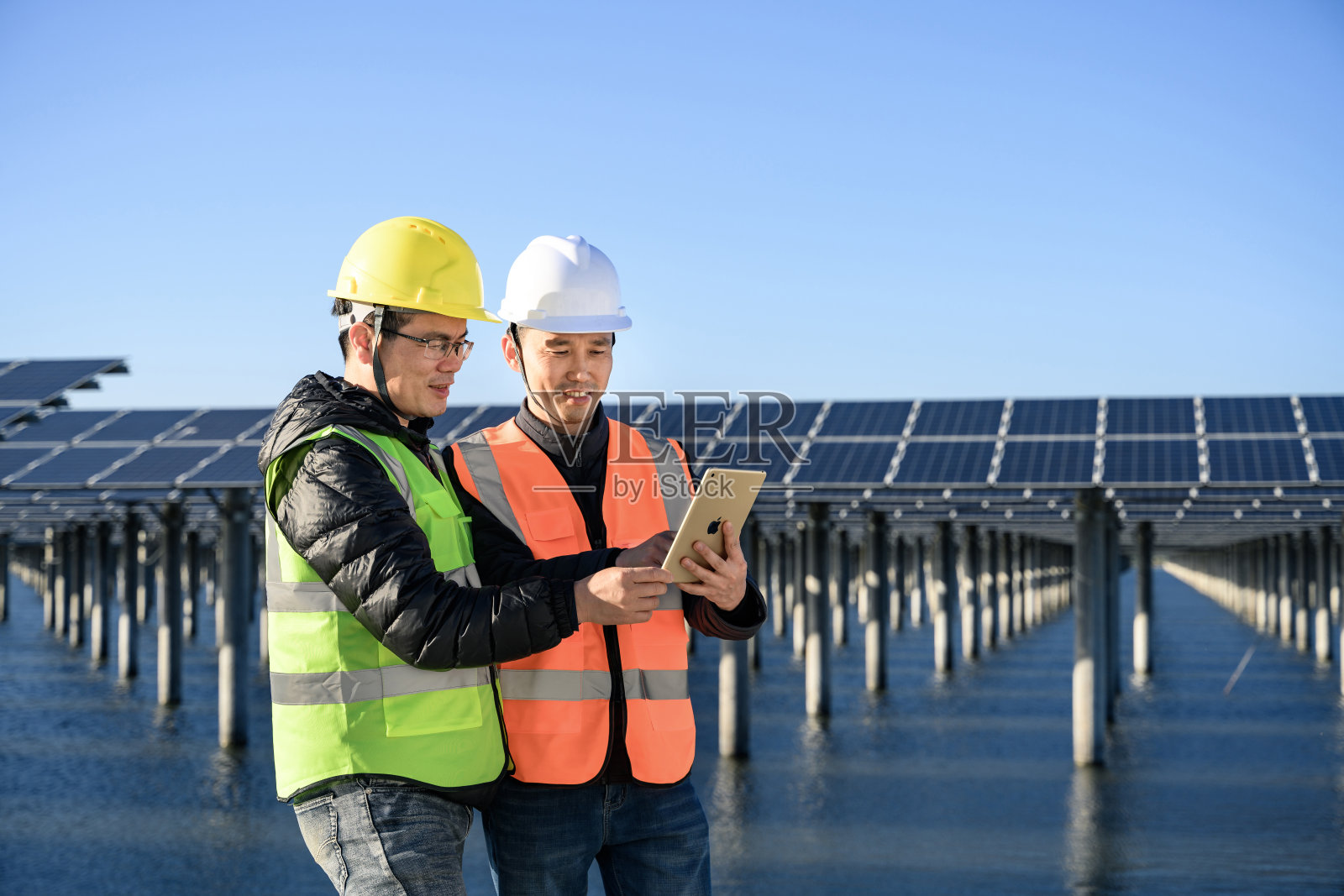 两名男工程师正在研究太阳能发电。照片摄影图片